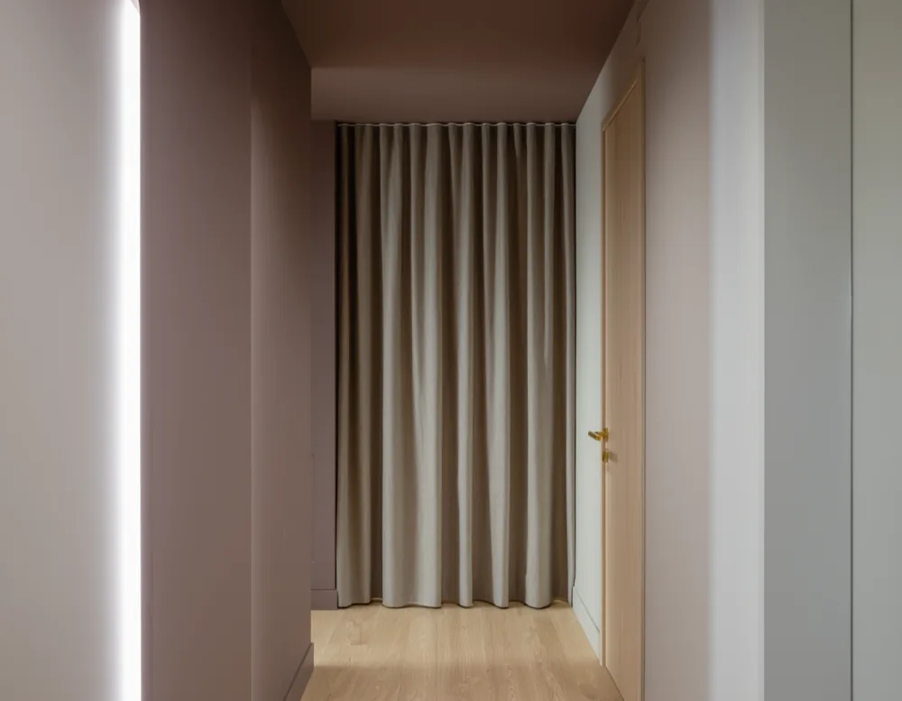 The practice corridor with a closed treatment room door and a drawn linen curtain.